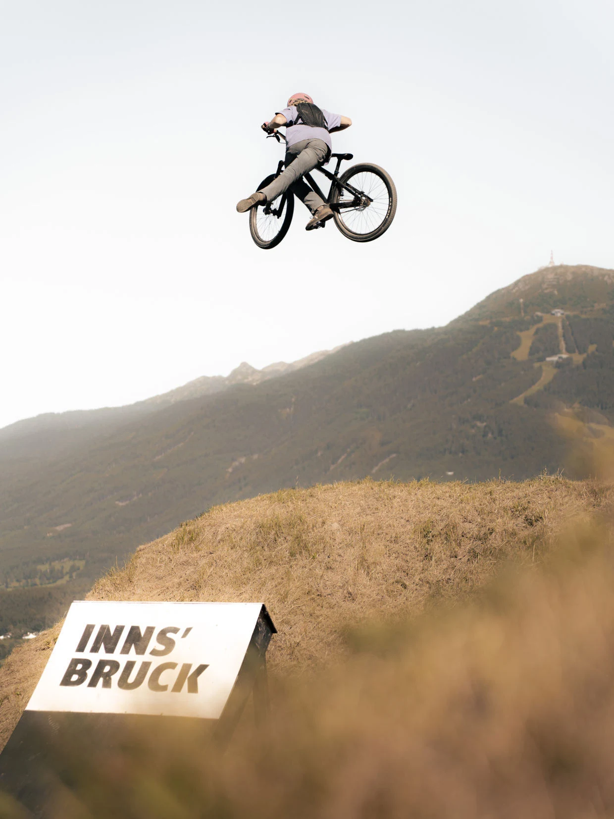 Rider hoch über der Dirtline mit Bergen im Hintergrund