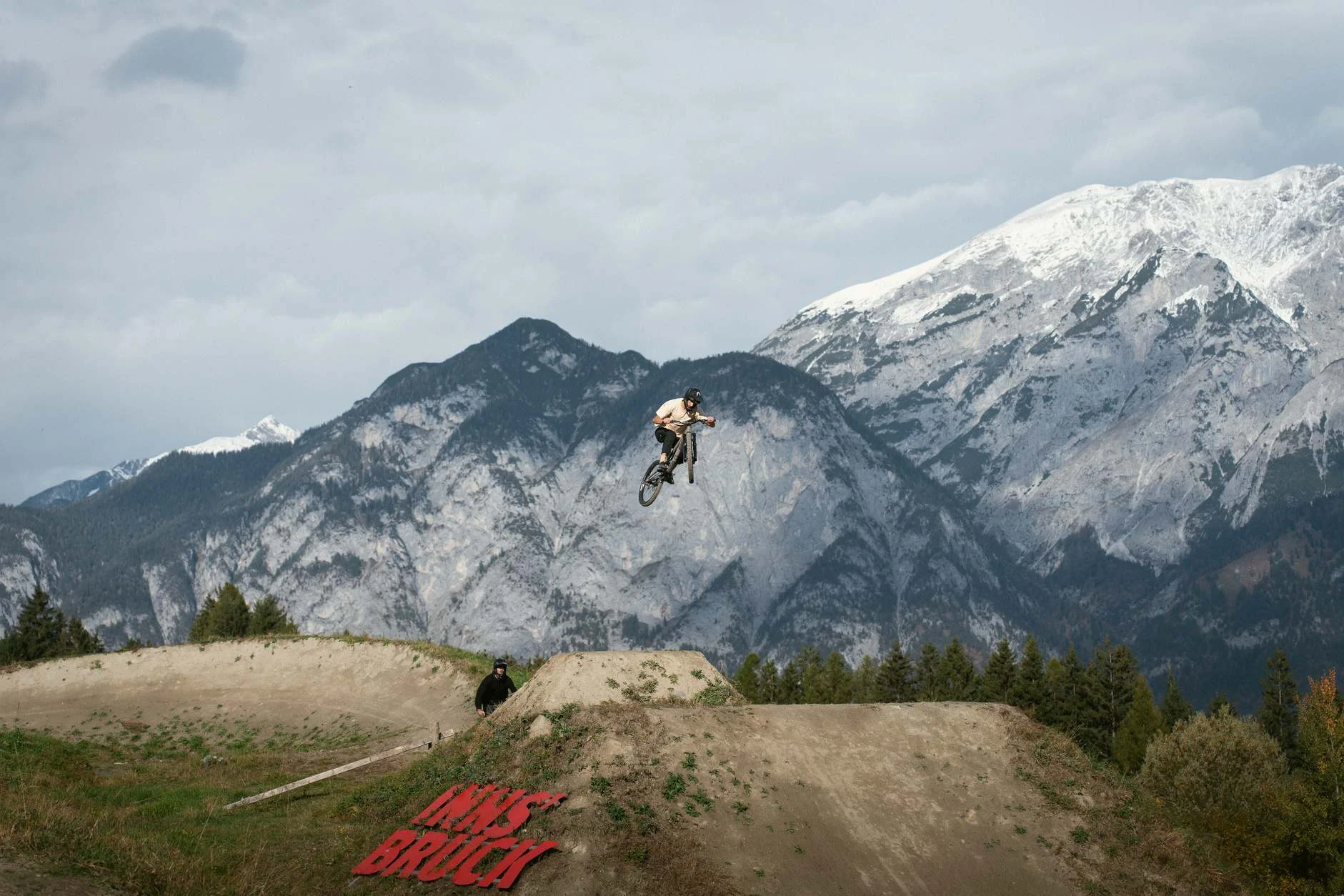 Mountainbiker beim Sprung am Compound vor der Tiroler Bergkulisse